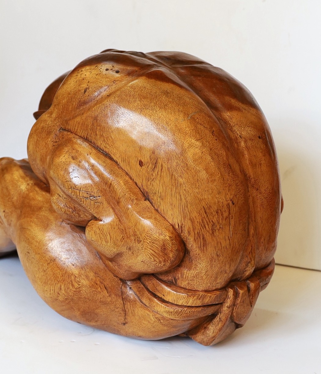 A Malaysian carved hardwood figure of the weeping Buddha, length 60cm. height 26cm